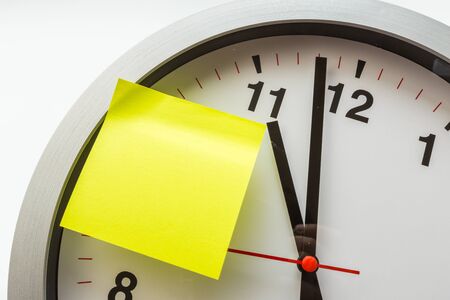 paper stick on clock for notice something with white background - Imageの写真素材