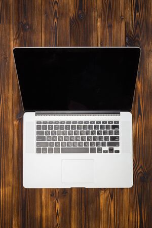 laptop on wooden background top view- Imageの写真素材