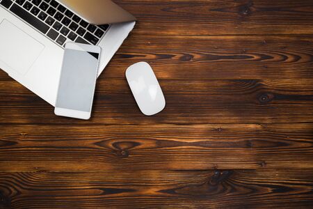 laptop and smartphone on wooden background top view- Imageの写真素材