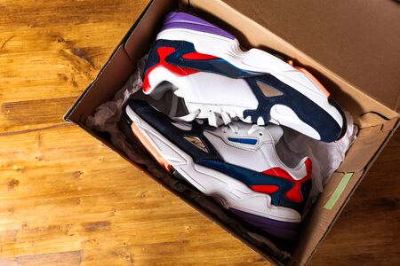 new sneakers in the box on wooden background- Imageの写真素材