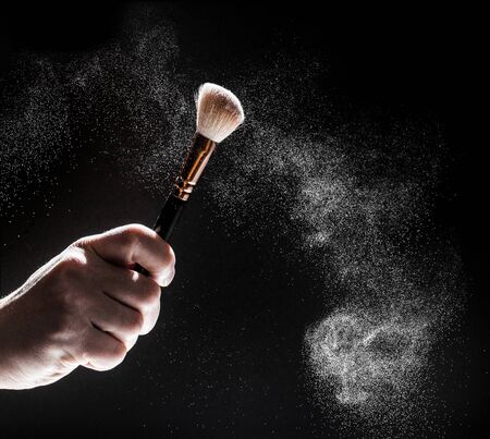 thick black brush in motion and loose powder particles scattered around  - Imageの写真素材