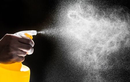 bottle nozzle spraying water on black background  - Imageの写真素材