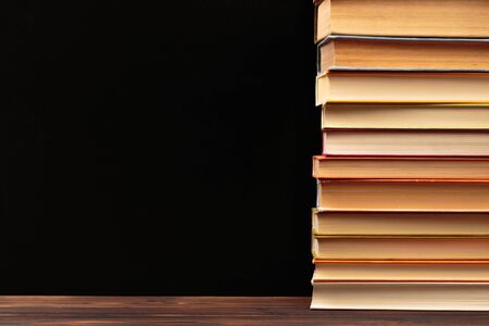 Stack of books on a black  background.Education. - Imageの写真素材