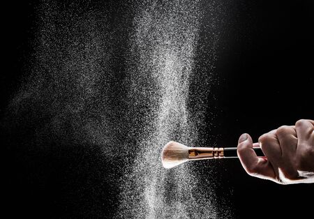 thick black brush in motion and loose powder particles scattered around  - Imageの写真素材