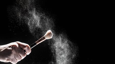 thick black brush in motion and loose powder particles scattered around  - Imageの写真素材