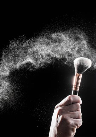 thick black brush in motion and loose powder particles scattered around  - Imageの写真素材