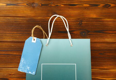 Paper bag on wooden  background with sale tag .  Mockup for design - Imageの写真素材