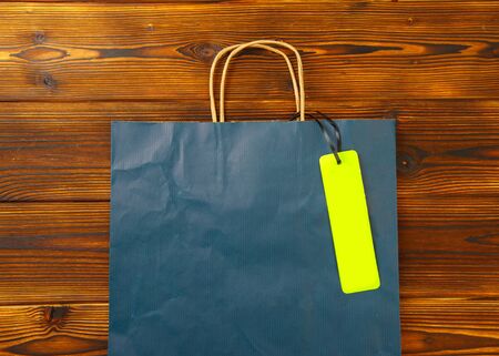 Paper bag on wooden  background with sale tag .  Mockup for design - Imageの写真素材