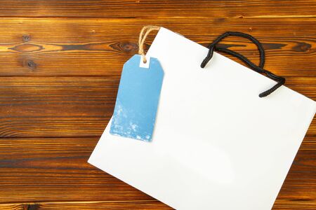 Paper bag on wooden  background with sale tag .  Mockup for design - Imageの写真素材