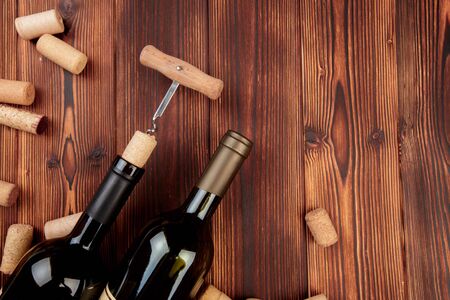 Glass bottle of wine with corks on wooden table backgroundの写真素材