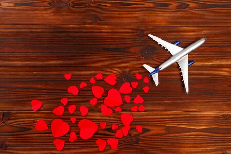 White blank model of passenger airplane on shapes of heart over wooden background - Imageの写真素材