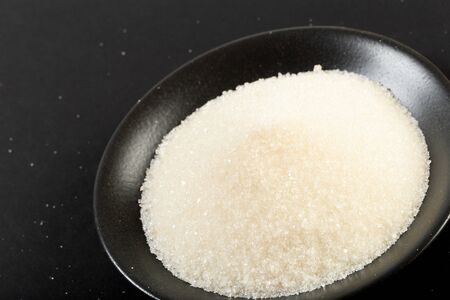 bowl of sugar  on black background - Image