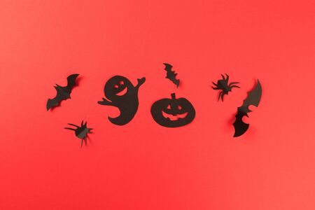 Halloween paper decorations on red background. Halloween concept. Flat lay, top view, copy space