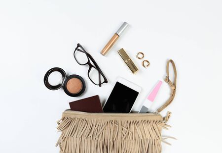 Fashion concept : Flat lay of brown leather woman bag open out with sunglasses and smartphone on white background.の写真素材