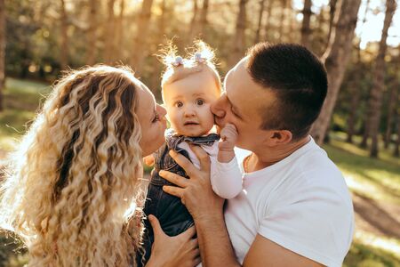 Happy family father, mother and child daughter outdoor  enjoying  sunsetの写真素材