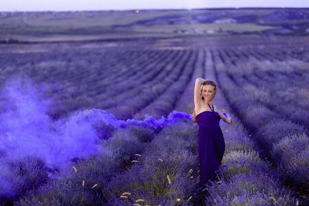 Beautiful girl on the lavender field with colored smoke Beautiful woman in the lavender field on sunset. - Imageの写真素材