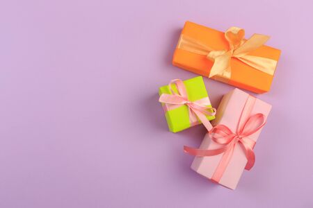 Different colored gift box on color background. Top view of various present boxes on minimal background. Birthday, Christmas, wedding, valentine, romantic giftsの写真素材