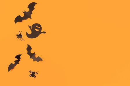 Halloween paper decorations on orange background. Halloween concept. Flat lay, top view, copy space