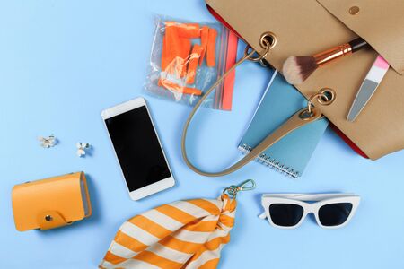Top view of Women bag and lady stuff with copyspace on blue  backgroundの写真素材
