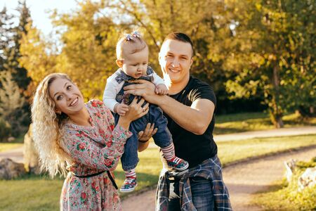 Happy family father, mother and child daughter outdoor  enjoying  sunsetの写真素材