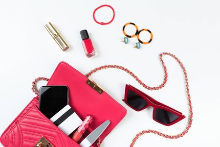 Fashion concept : Flat lay of purple leather woman bag open out with sunglasses and smartphone on...
