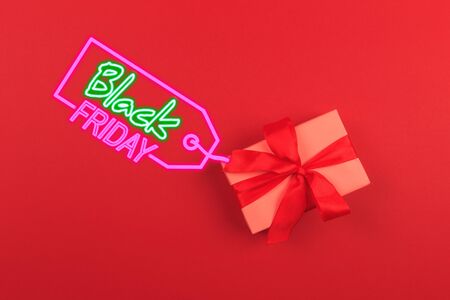 Gift box with ribbon and bow on color background and space for text. Black friday sale