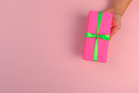 gift in female hands on a colored background top view.の写真素材