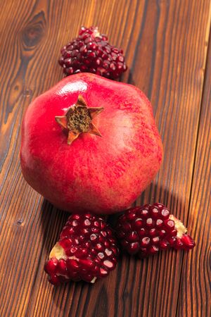 Ripe pomegranate fruit on wooden vintage background.の写真素材