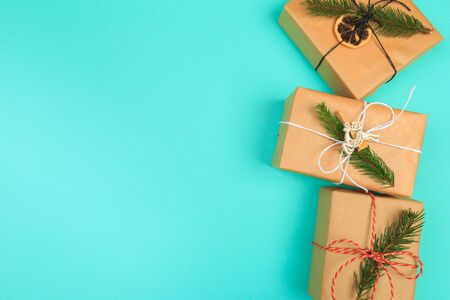 Christmas border. Christmas gifts, fir branches on color background. Flat lay, top view, copy space