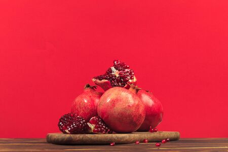 Ripe pomegranate fruit on a red  background.の写真素材