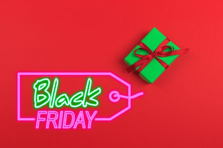Gift box with ribbon and bow on color background and space for text. Black friday saleの写真素材
