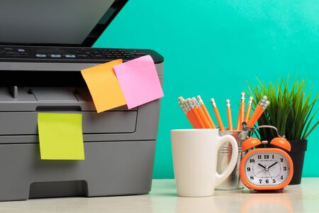 Printer, copier, scanner on color background . Office table