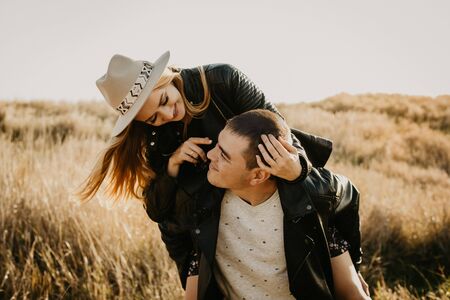 Happy young couple enjoying outdoors during sunset - Image