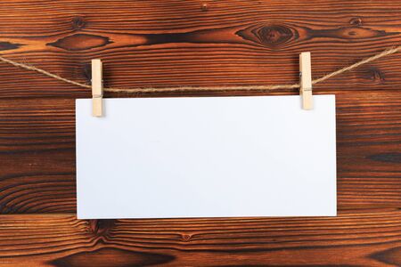 paper attach to rope with clothes pins on wooden background