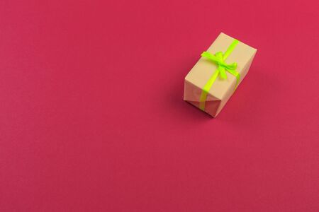 Gift box with ribbon and bow on color background and space for text. Top view
