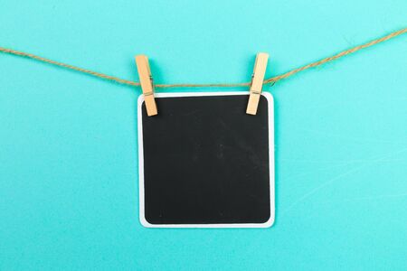 writing board attached to a rope clothespin on blue  background