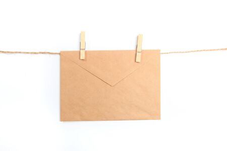 Old paper envelope hanging on rope on white backgroundの写真素材