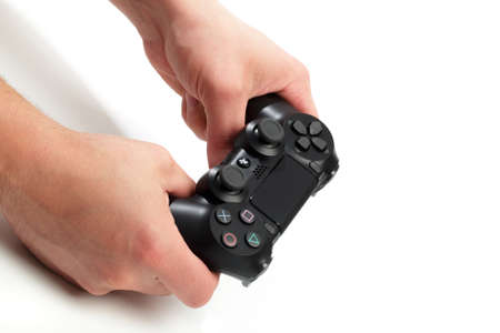 Russia, OKTOBER 24 2019: mans hands holding  new Sony Dualshock 4 with PlayStation 4. Sony PlayStation 4 game console of the eighth generation.のeditorial素材