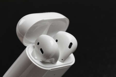 Air Pods. with Wireless Charging Case. New Airpods 2019 on black background.