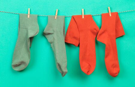 colorful   socks hanging on a rope on pastel   backgroundの写真素材