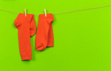 colorful   socks hanging on a rope on green   backgroundの写真素材