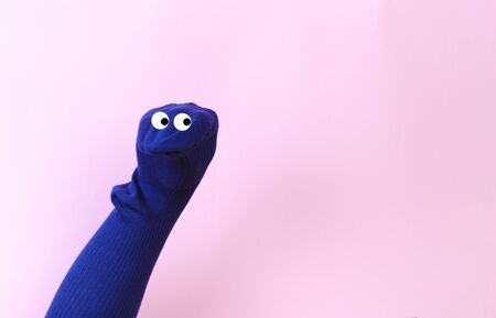 funny doll sock on pink background, hand theaterの写真素材
