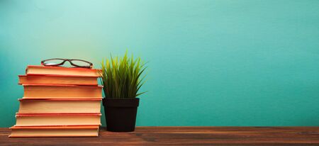 pile of old books with glasses panorma, good copy space  on blue background - Imageの写真素材