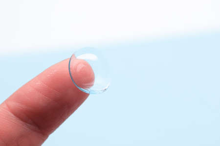 contact lenses on the finger on blue backgroundの写真素材
