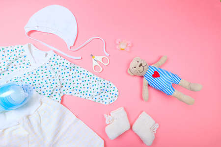 Baby concept. Baby cloth and goods on pastel pink background. Place for text. View from above. Flat...
