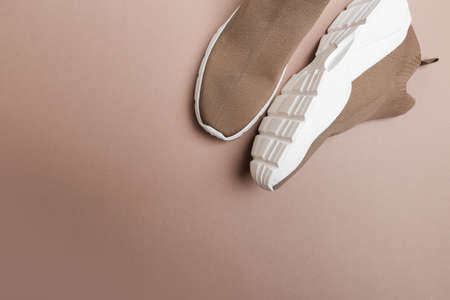 modern beige sneakers with white soles on beige backgroundの写真素材
