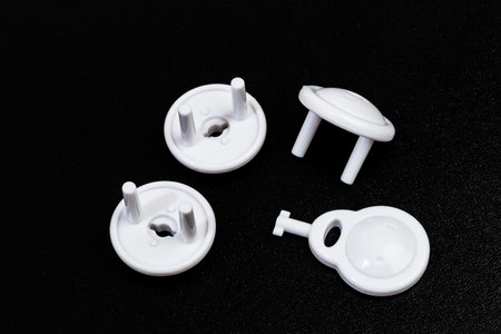 Protective Socket plugs on black  background  child safety