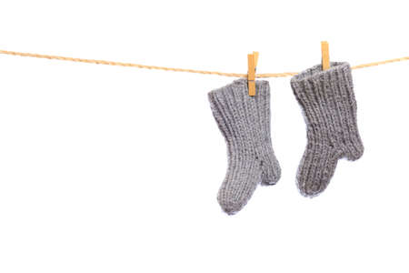 Baby clothes on a clothesline on white  background . knitted socks- Imageの写真素材