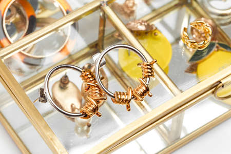 earrings in yellow and white metal rock theme on glass jewelry box  - image