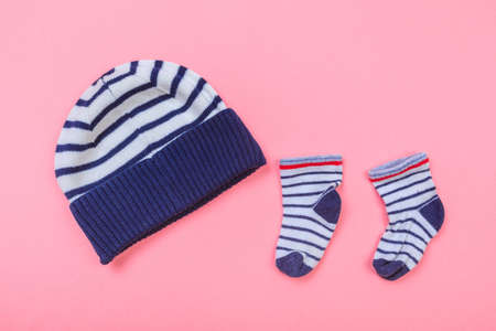baby hat and little socks on pastel pink background - Image